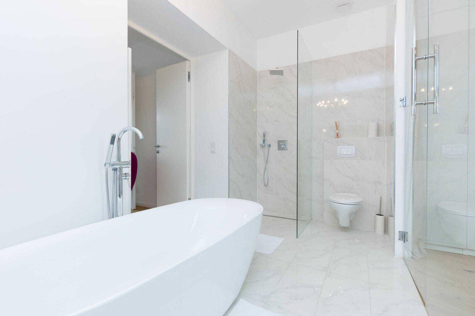 Modernes Badezimmer mit freistehender Badewanne, begehbarer Dusche und Marmorfliesen.