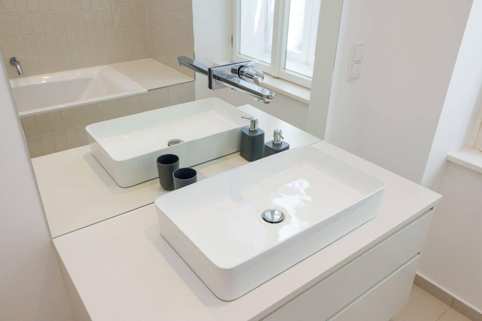 Modernes Aufsatzwaschbecken mit minimalistischem Design und großem Spiegel im Badezimmer.