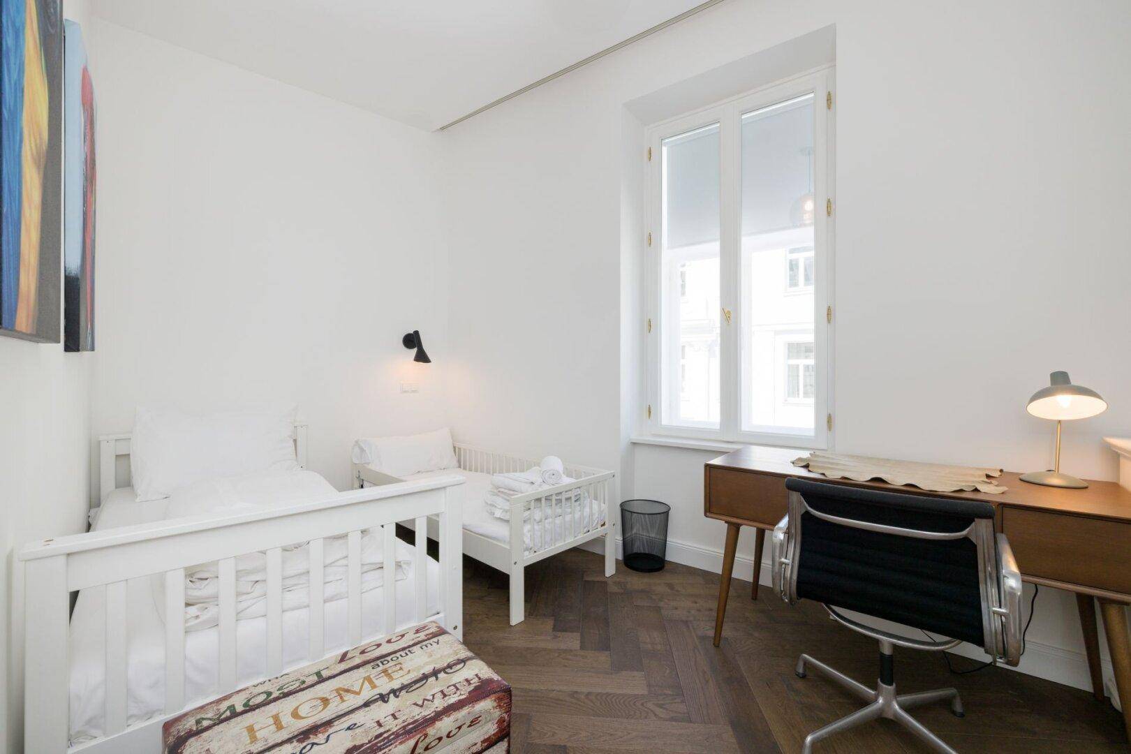 Kinderzimmer oder Gästezimmer mit zwei Einzelbetten und einem Schreibtisch.