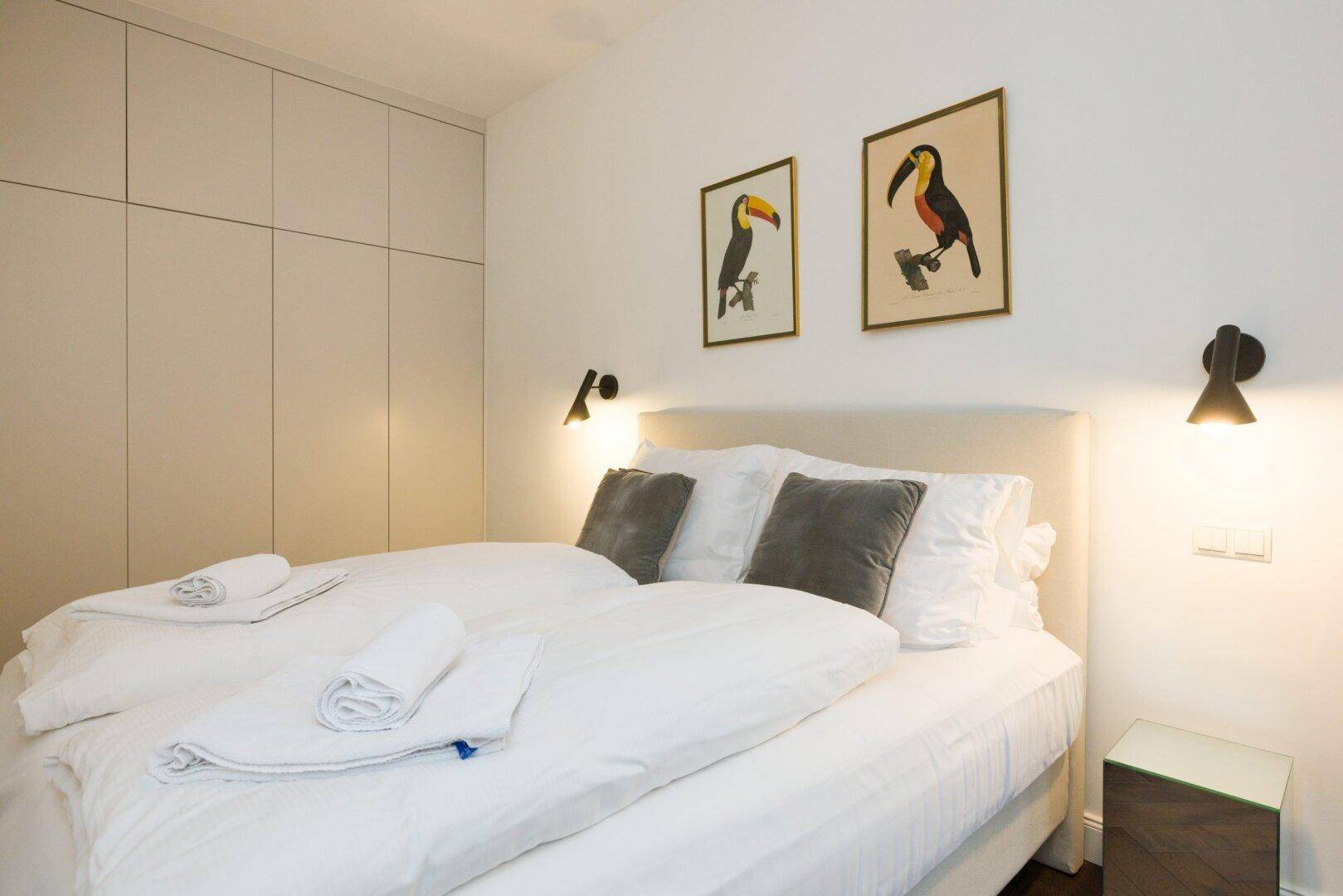 Gemütliches Schlafzimmer mit Doppelbett, Einbauschränken und dekorativen Bildern.