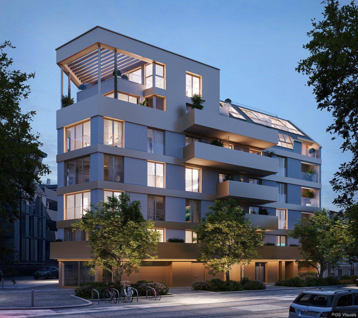 Modernes Wohngebäude bei Abenddämmerung mit beleuchteten Innenräumen und Balkonen.