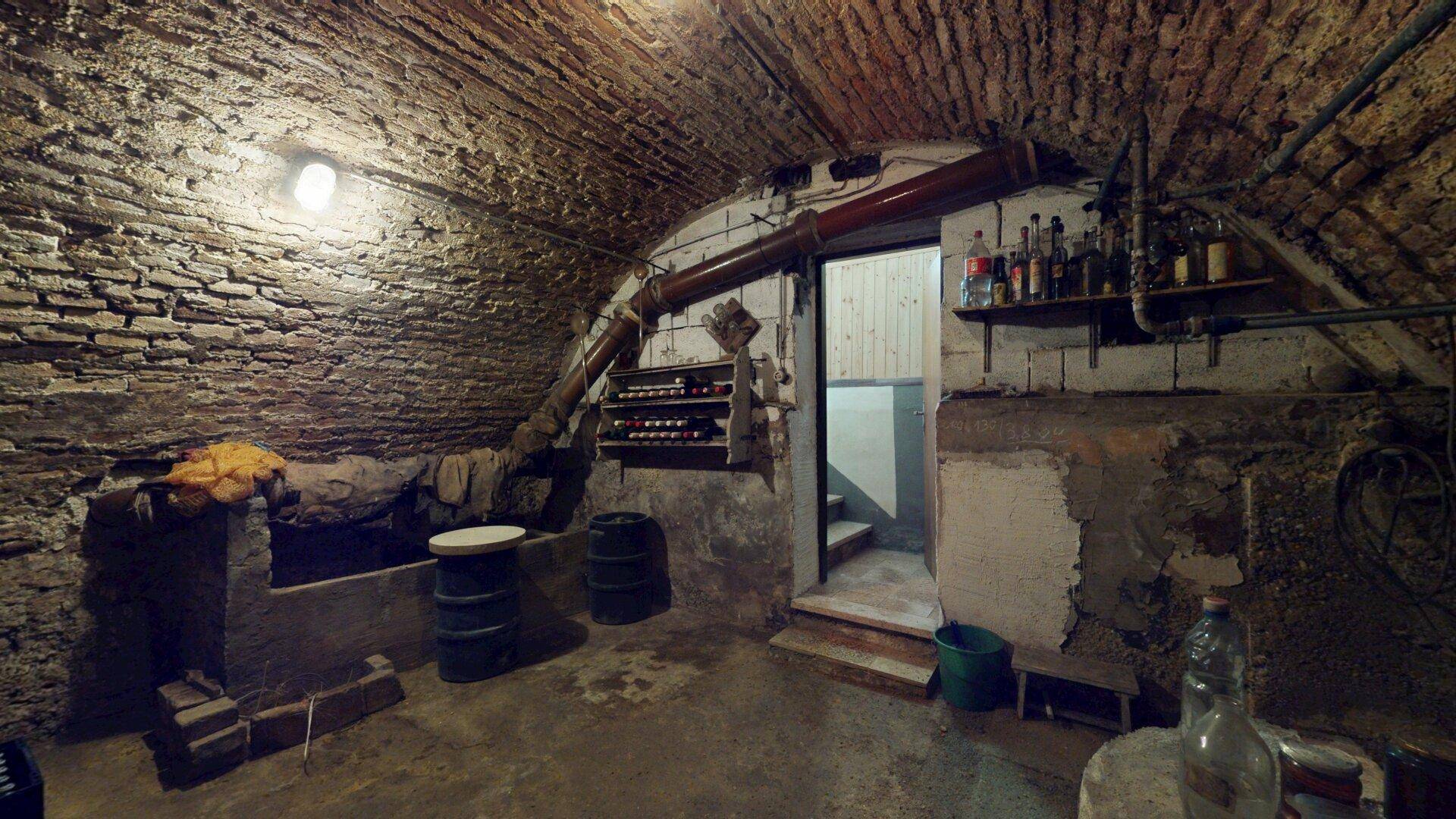 Historischer Gewölbekeller mit Ziegelwänden und -decke, ideal zur Weinlagerung.