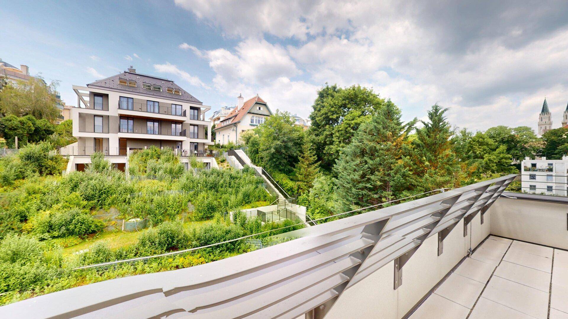 Panoramablick von der Dachterrasse auf die umliegende grüne Landschaft und moderne Gebäude.