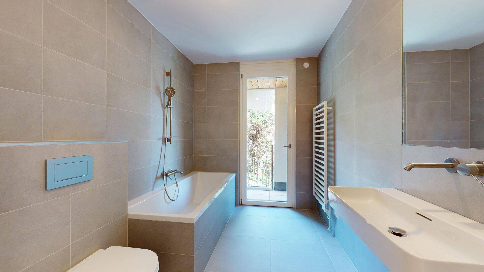 Modernes Badezimmer mit Badewanne, Dusche, wandhängendem WC und Zugang zu einem kleinen Balkon.