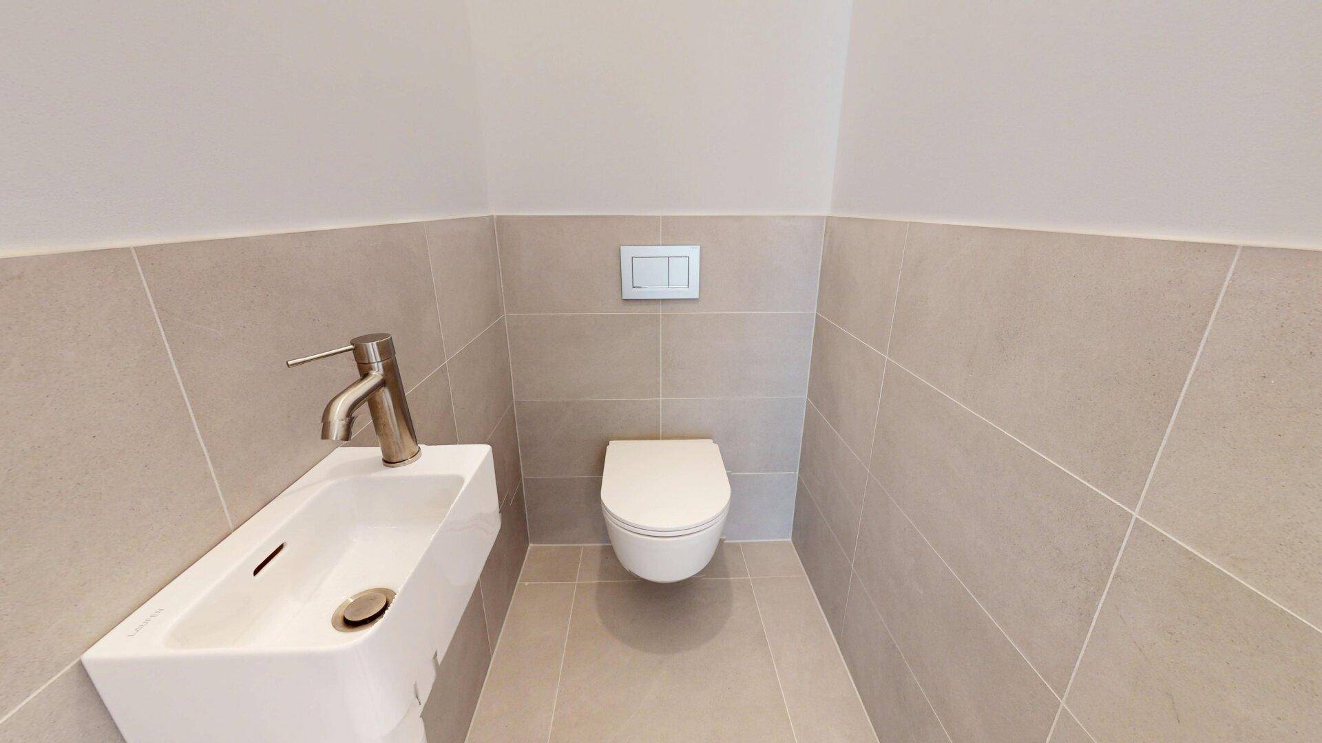 Modernes Gäste-WC mit beigefarbenen Fliesen, wandhängendem WC und kleinem Waschbecken.