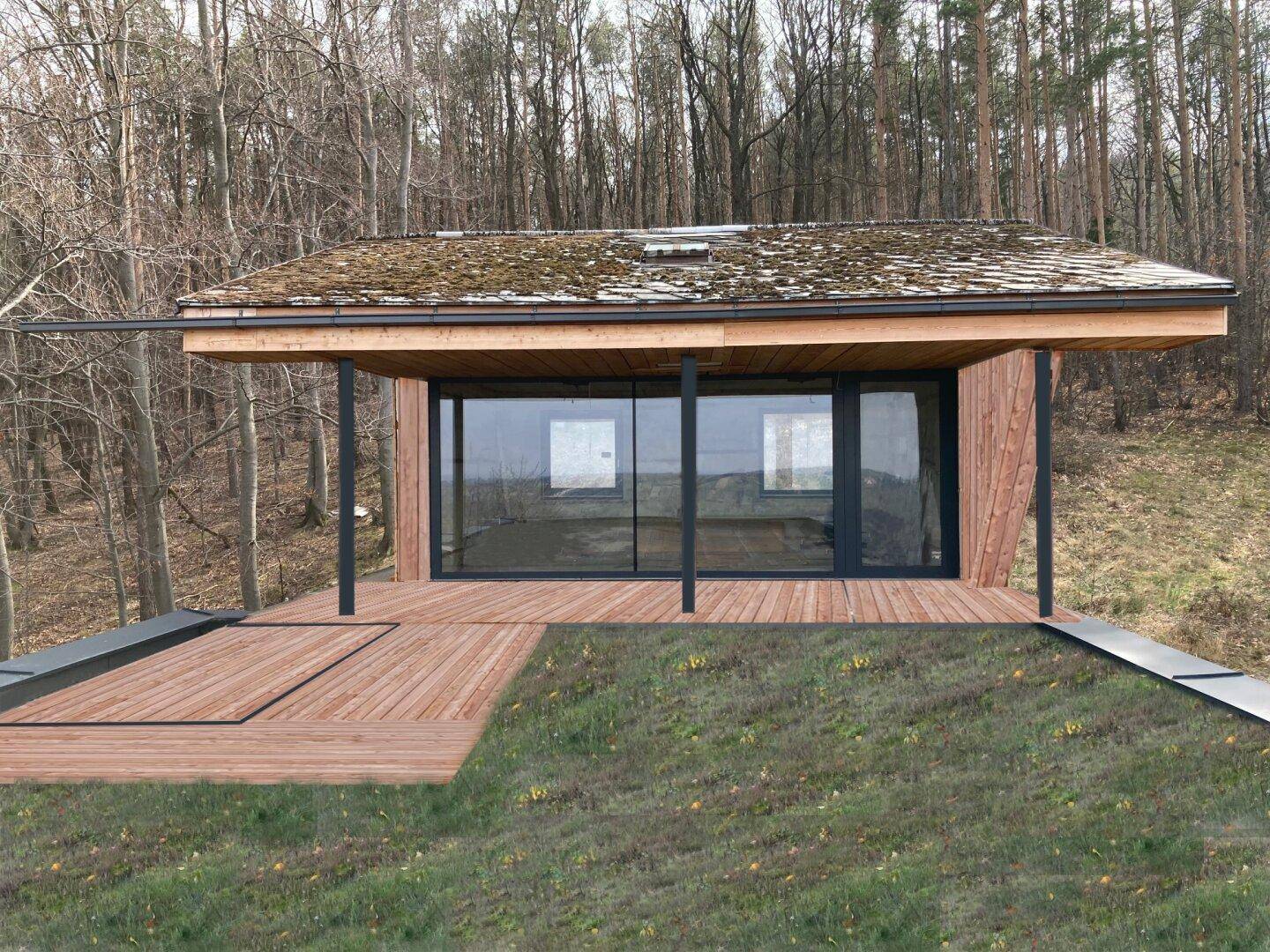 Modernes Haus mit Holzterrasse, großen Glasfronten und begrüntem Dach, umgeben von Wald.