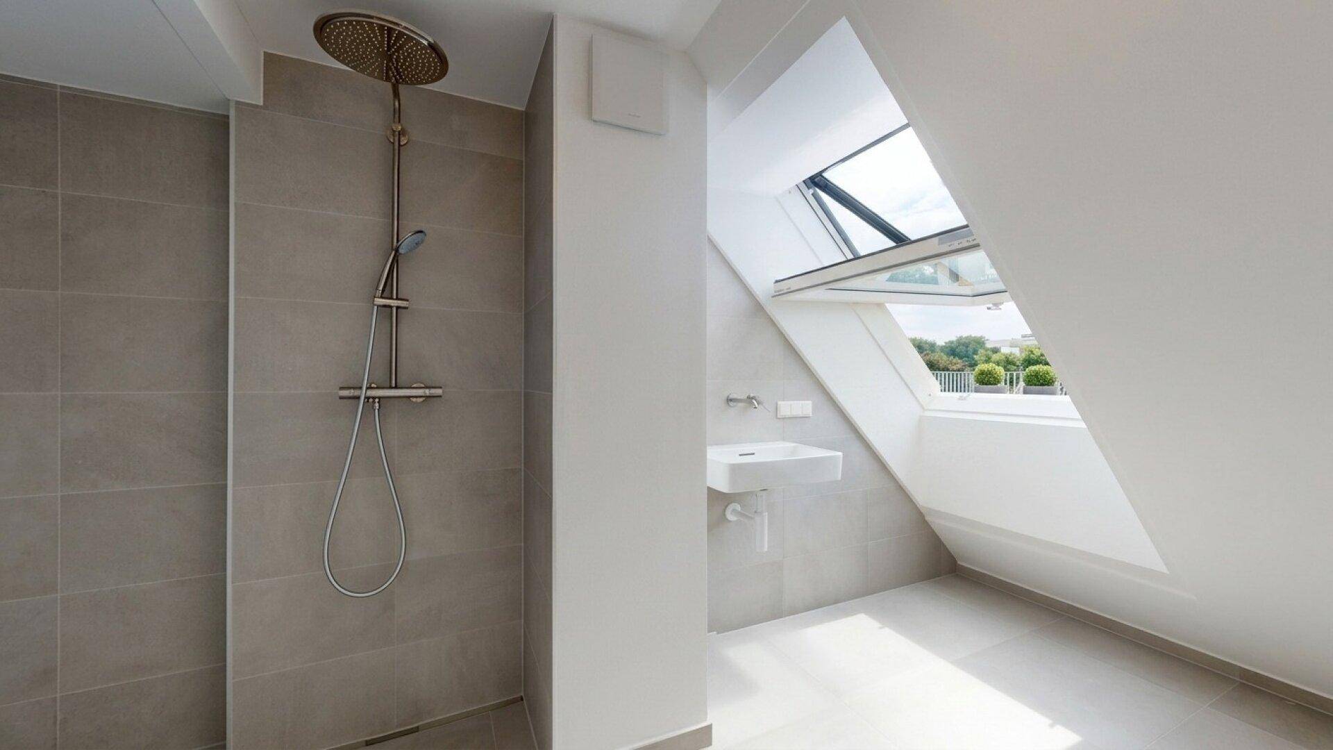 Modernes Badezimmer mit begehbarer Dusche, Dachfenster und hellgrauen Fliesen.
