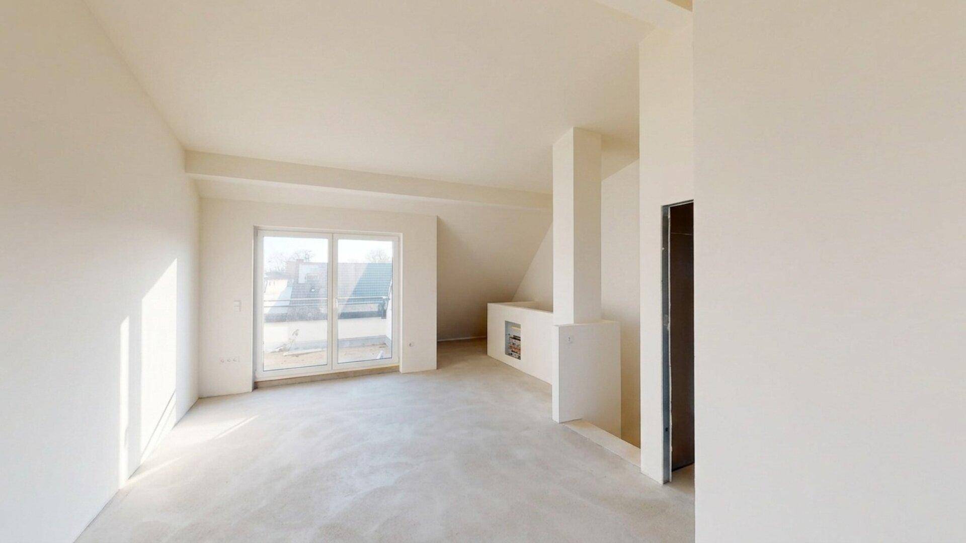 Heller, unfertiger Wohnraum im Dachgeschoss mit großen Fenstern und viel natürlichem Licht.