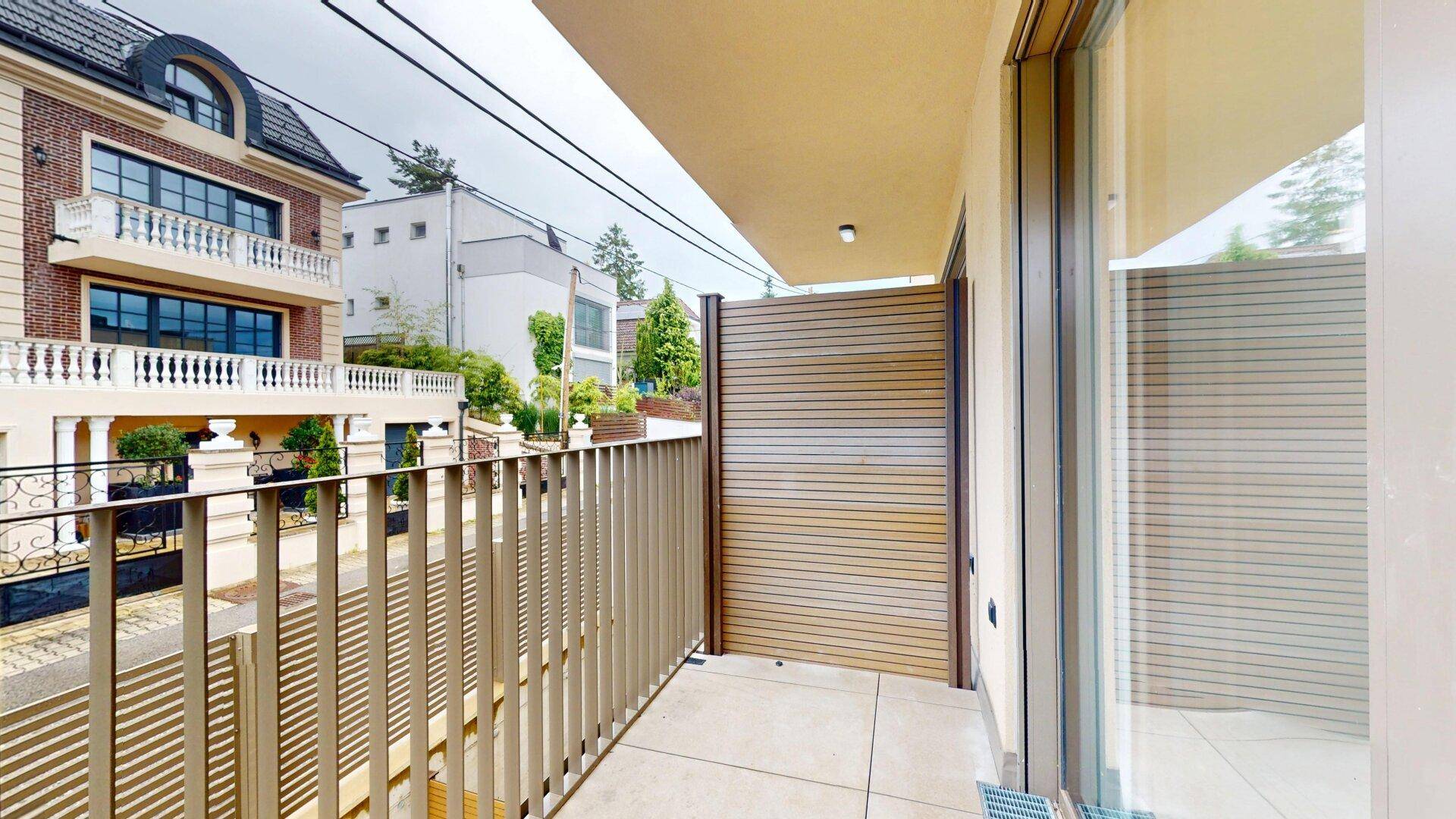 Schmaler Balkon mit modernem Geländer und Sichtschutz, bietet Privatsphäre im Freien.
