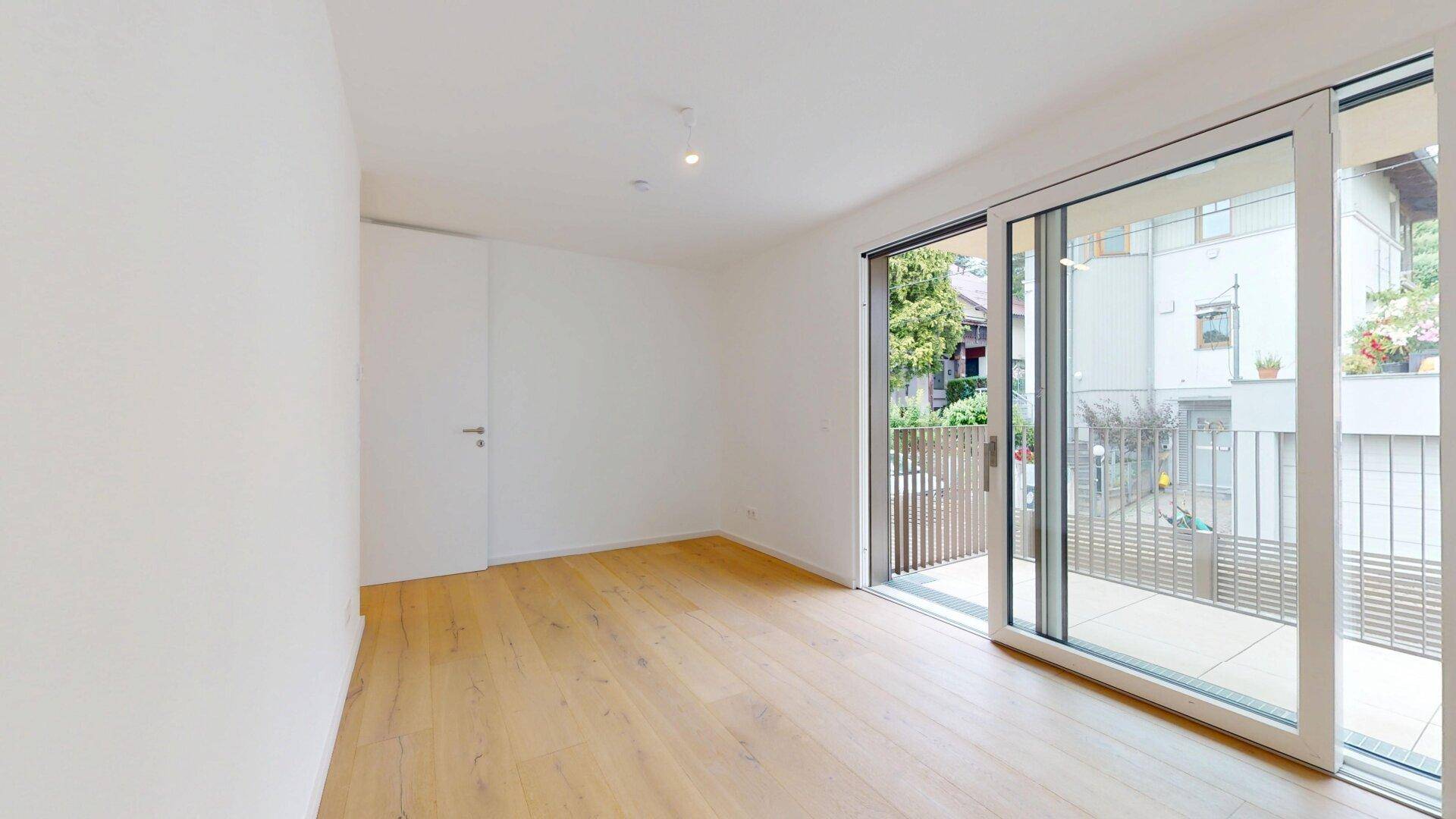 Geräumiges Zimmer mit Holzboden und direktem Zugang zu einem sonnigen Balkon.