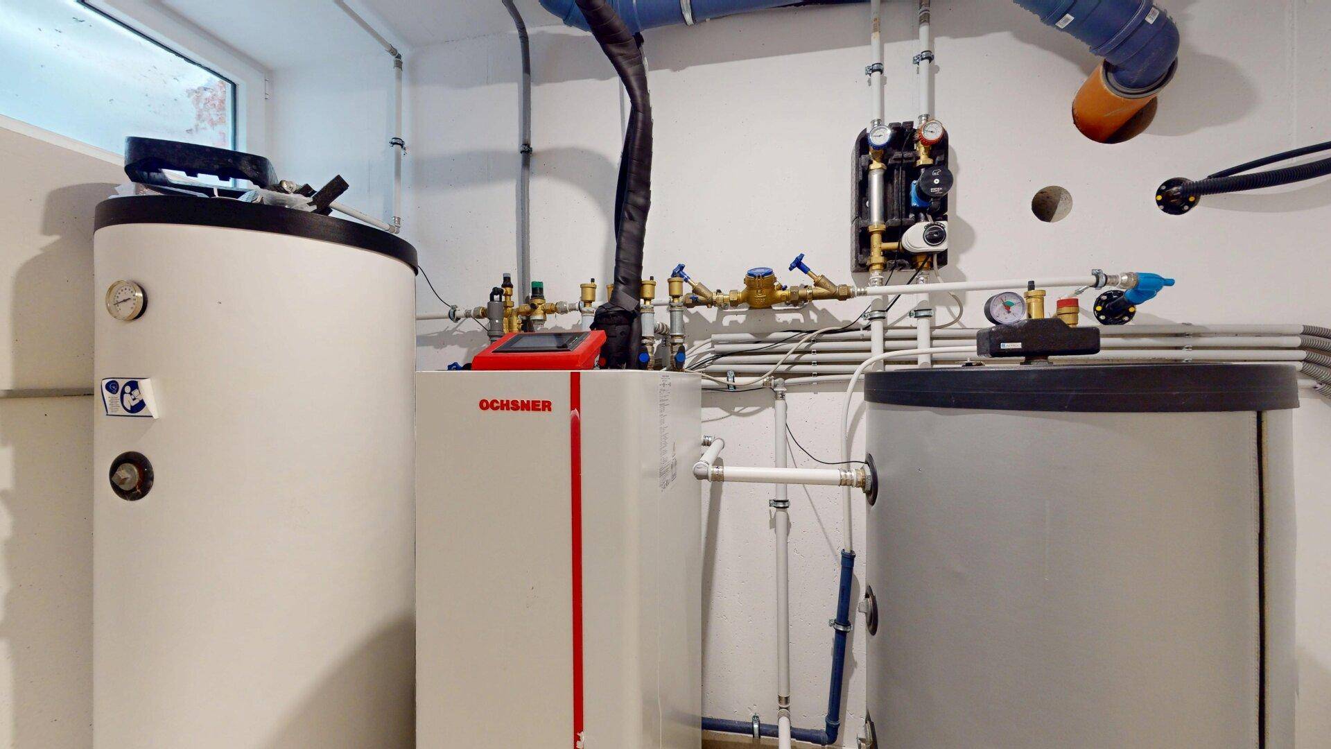 Technikraum mit moderner Heizungsanlage und Warmwasserspeichern für das Gebäude.