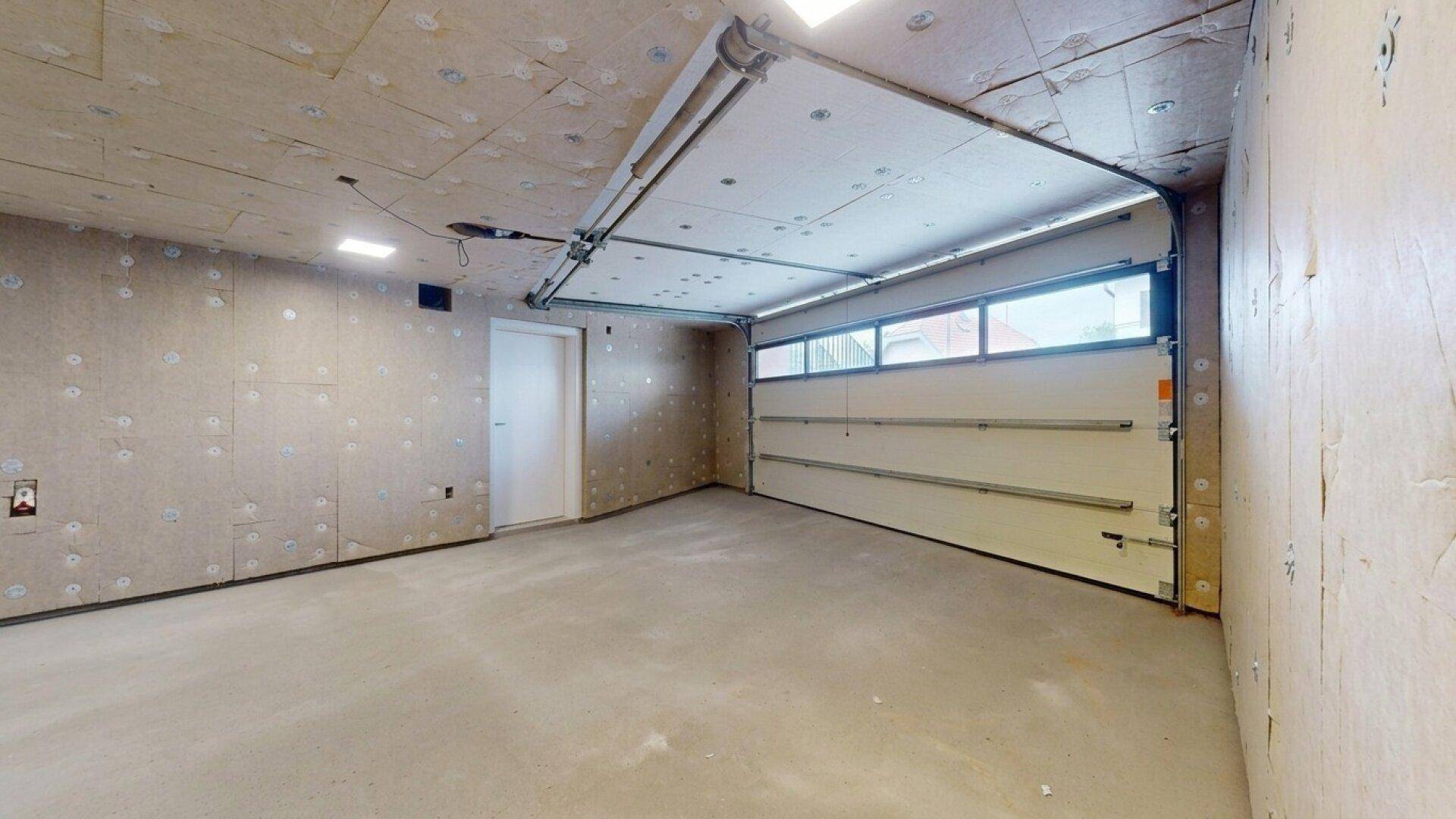 Geräumige Garage mit automatischem Tor und ausreichend Platz für Fahrzeuge.