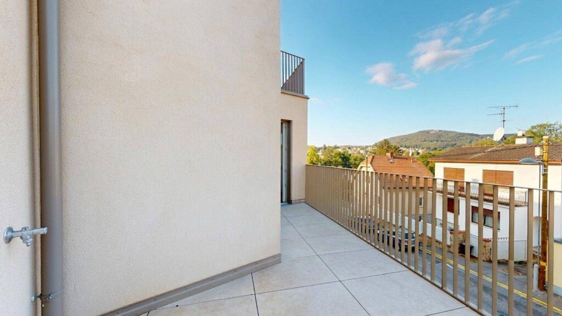 Schmaler Balkon mit modernem Geländer und Blick auf die umliegende Wohnbebauung.