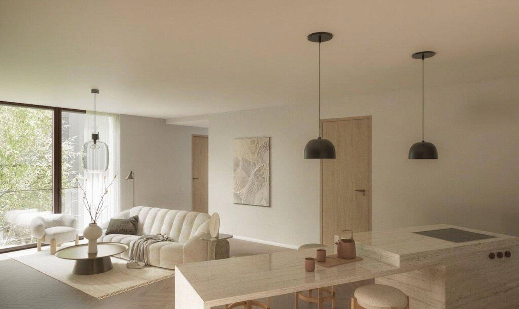 Helles Wohnzimmer mit modernem Sofa, Couchtisch und einer stilvollen Kücheninsel im Vordergrund.