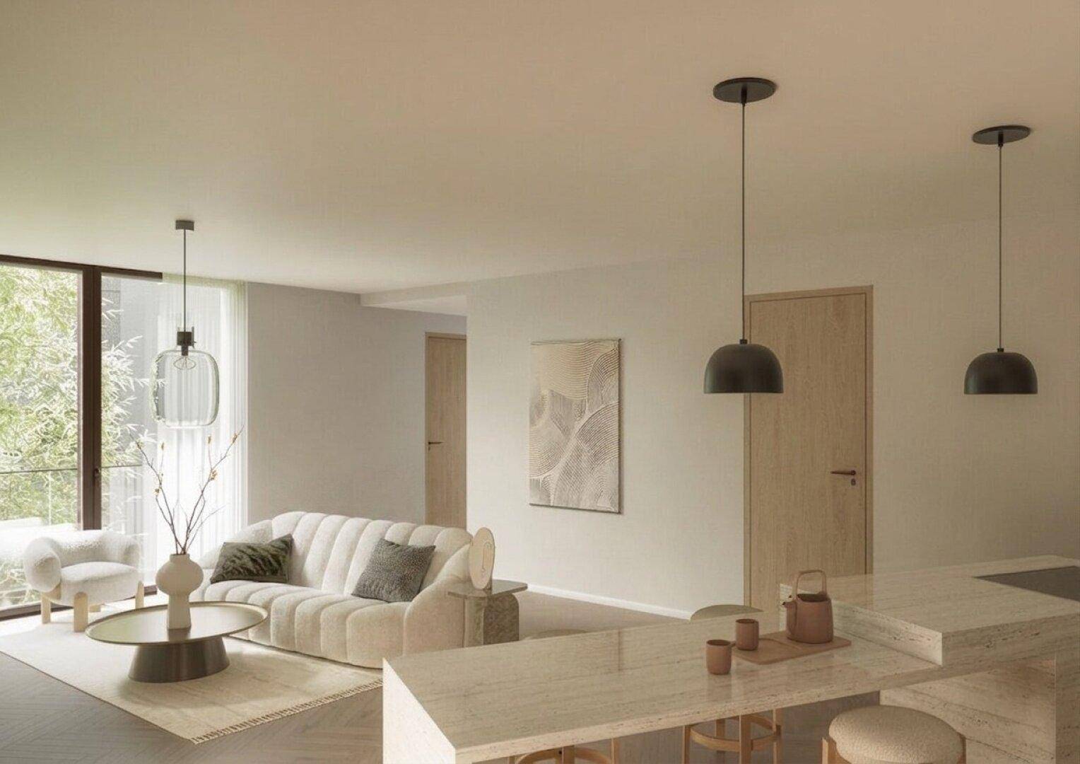 Helles Wohnzimmer mit modernem Sofa, Couchtisch und einer stilvollen Kücheninsel im Vordergrund.