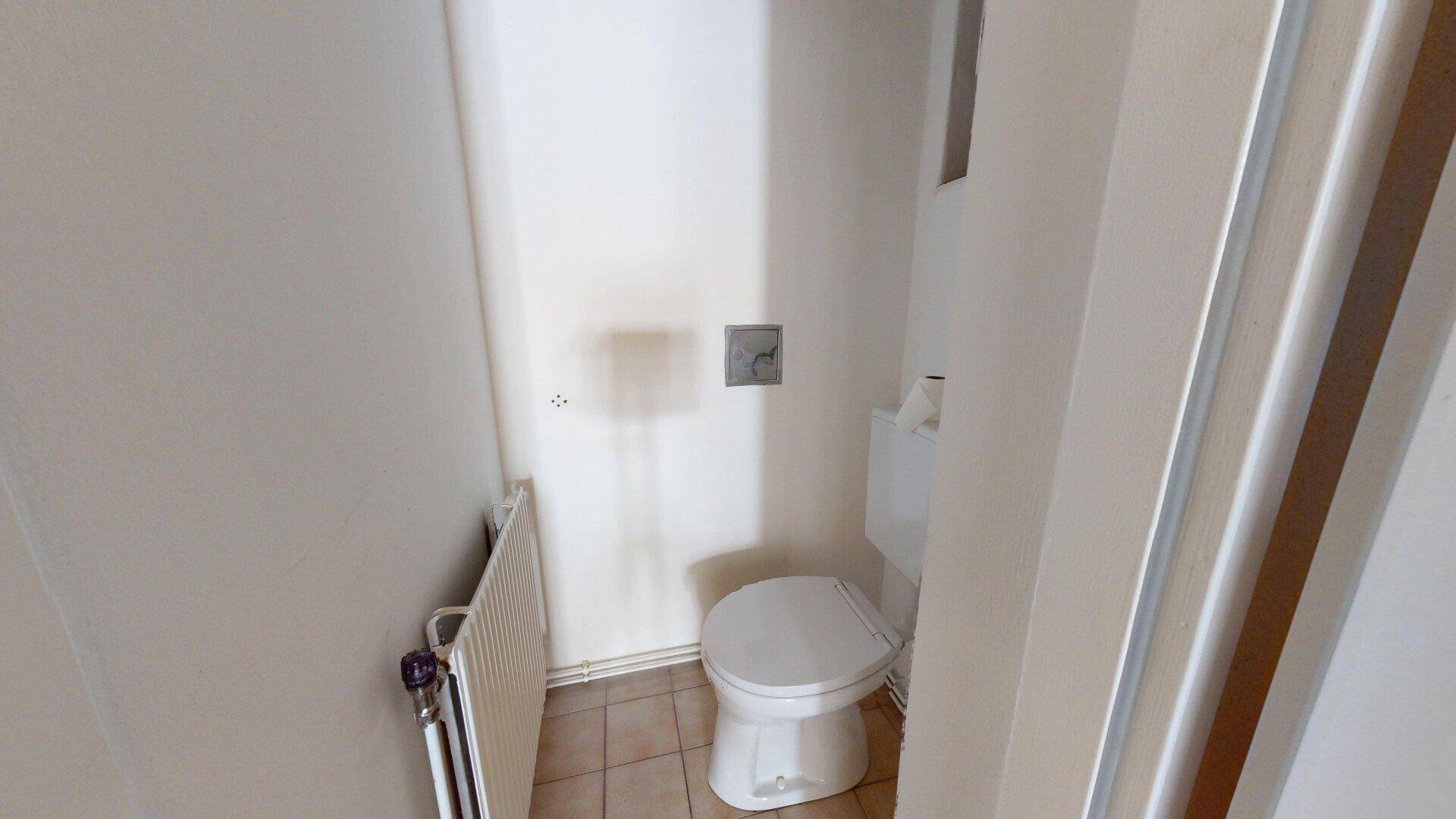 Kleines separates WC mit Toilette und Heizkörper, in einfacher Ausführung.