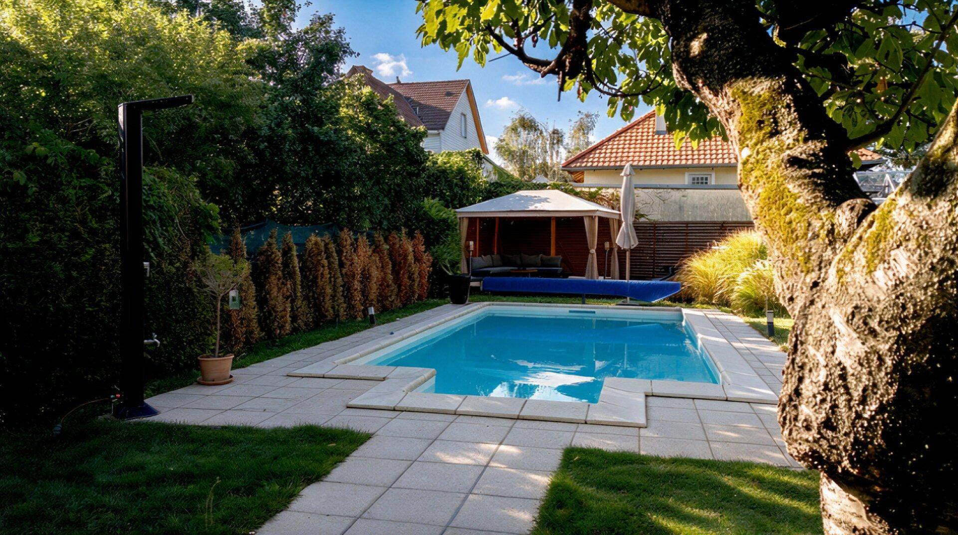 Blauer Pool im Garten mit gepflastertem Bereich, Rasen und einem gemütlichen Pavillon im Hintergrund.
