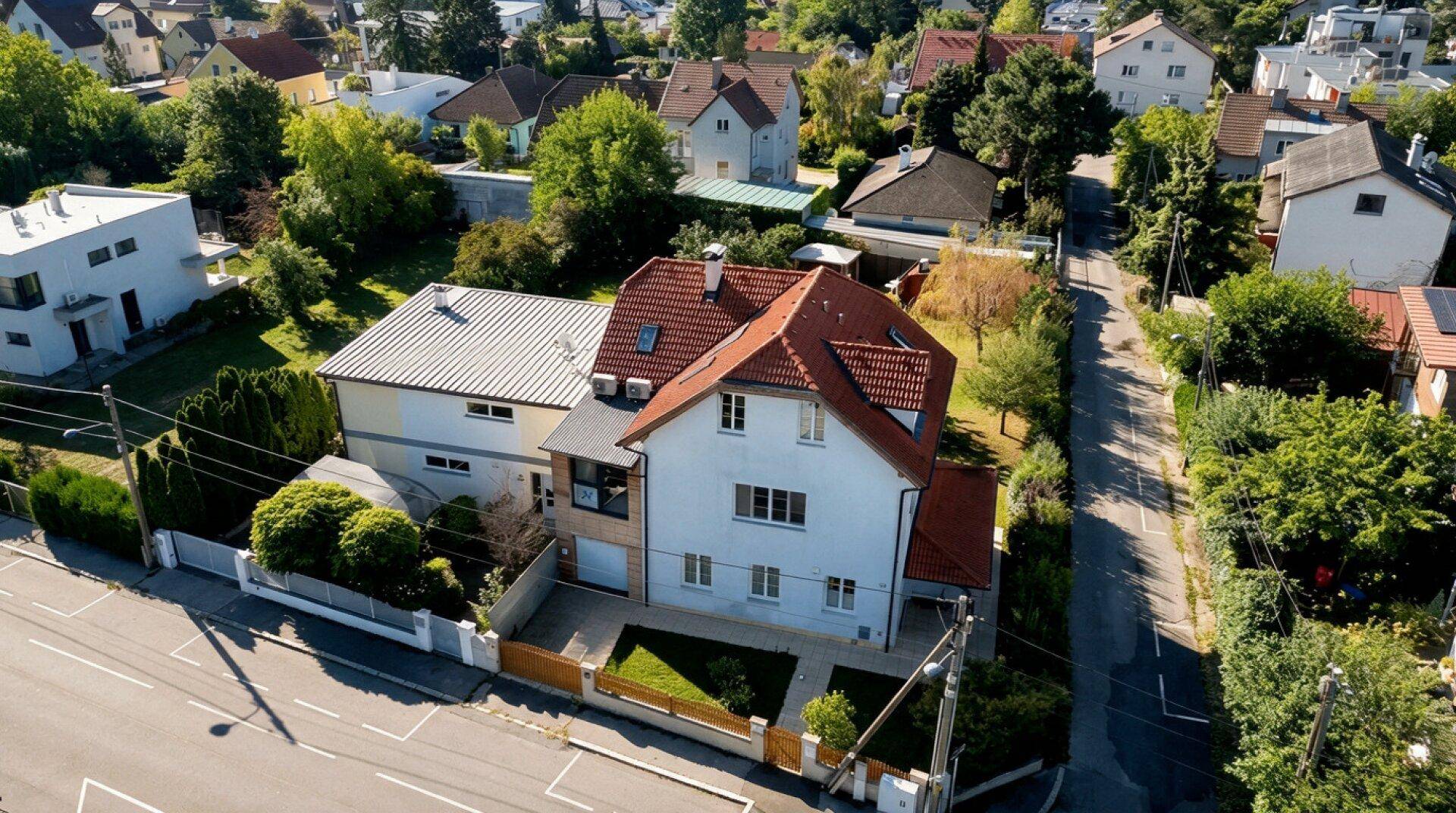 Luftaufnahme eines Einfamilienhauses mit Garten, Pool und umliegender Wohnbebauung.