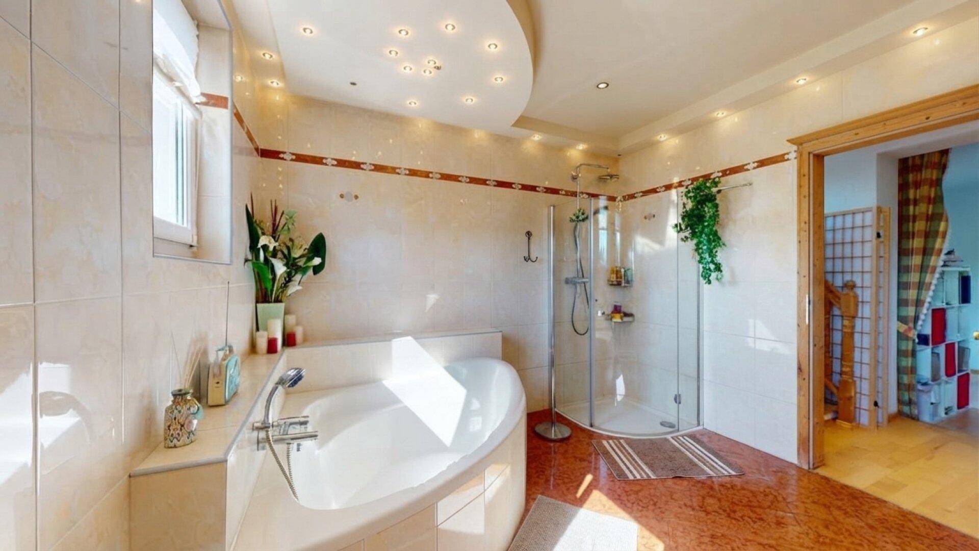 Geräumiges Badezimmer mit Eckbadewanne, Duschkabine und hellen Fliesen.