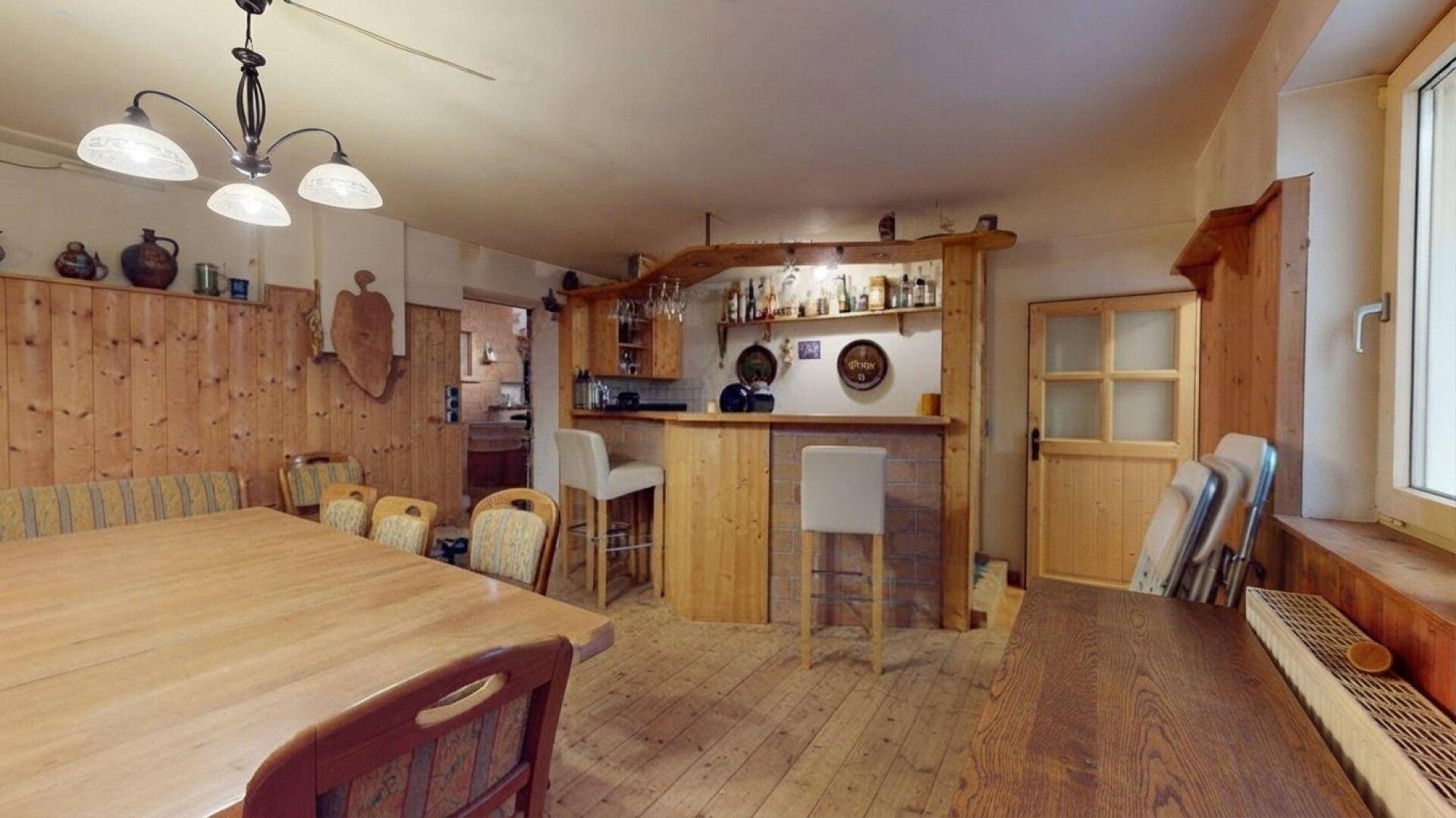 Rustikaler Wohn- und Essbereich mit Holztäfelung, Esstisch und einer gemütlichen Hausbar.