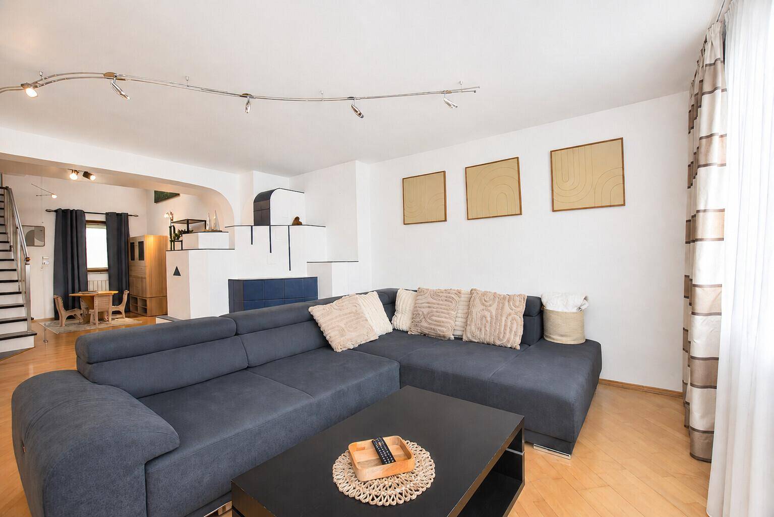 Komfortables Wohnzimmer mit großem Sofa, Couchtisch und hellem Holzboden.