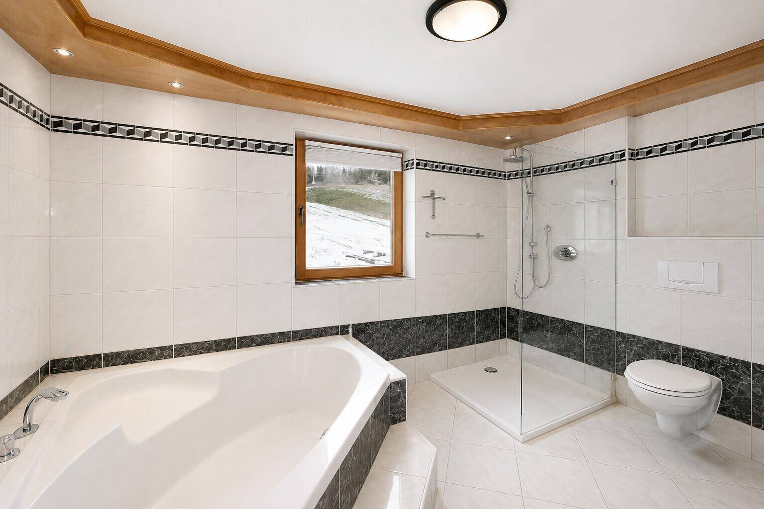 Modernes Badezimmer mit Badewanne, ebenerdiger Dusche und WC.