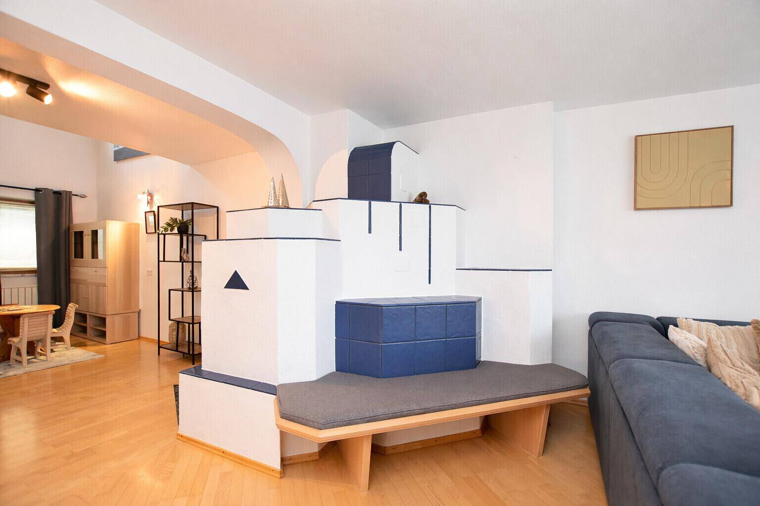 Helles Wohnzimmer mit modernem Kachelofen, Holzboden und offener Gestaltung.