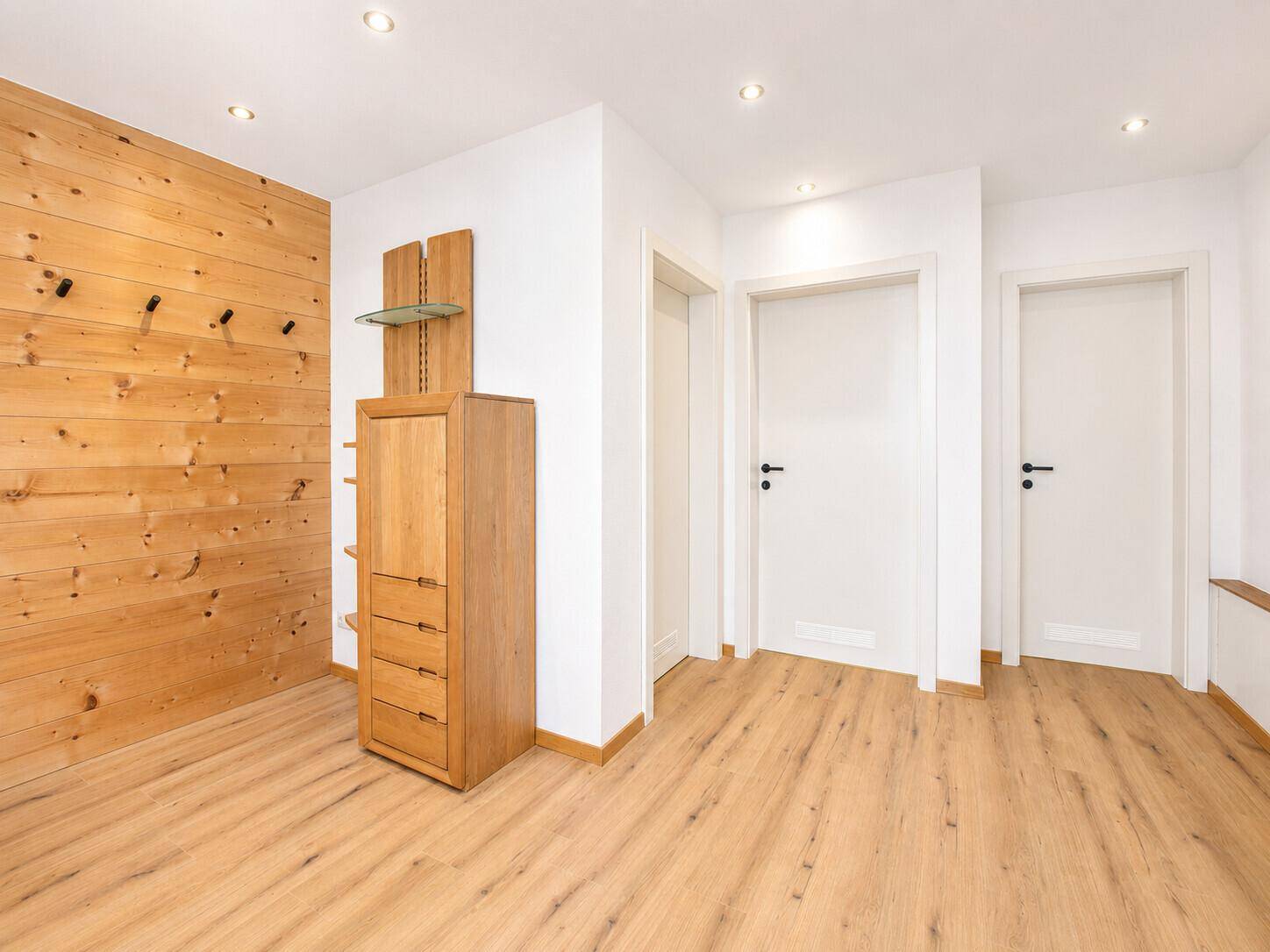 Geräumiger Flur mit Holzwandverkleidung und praktischem Stauraum.