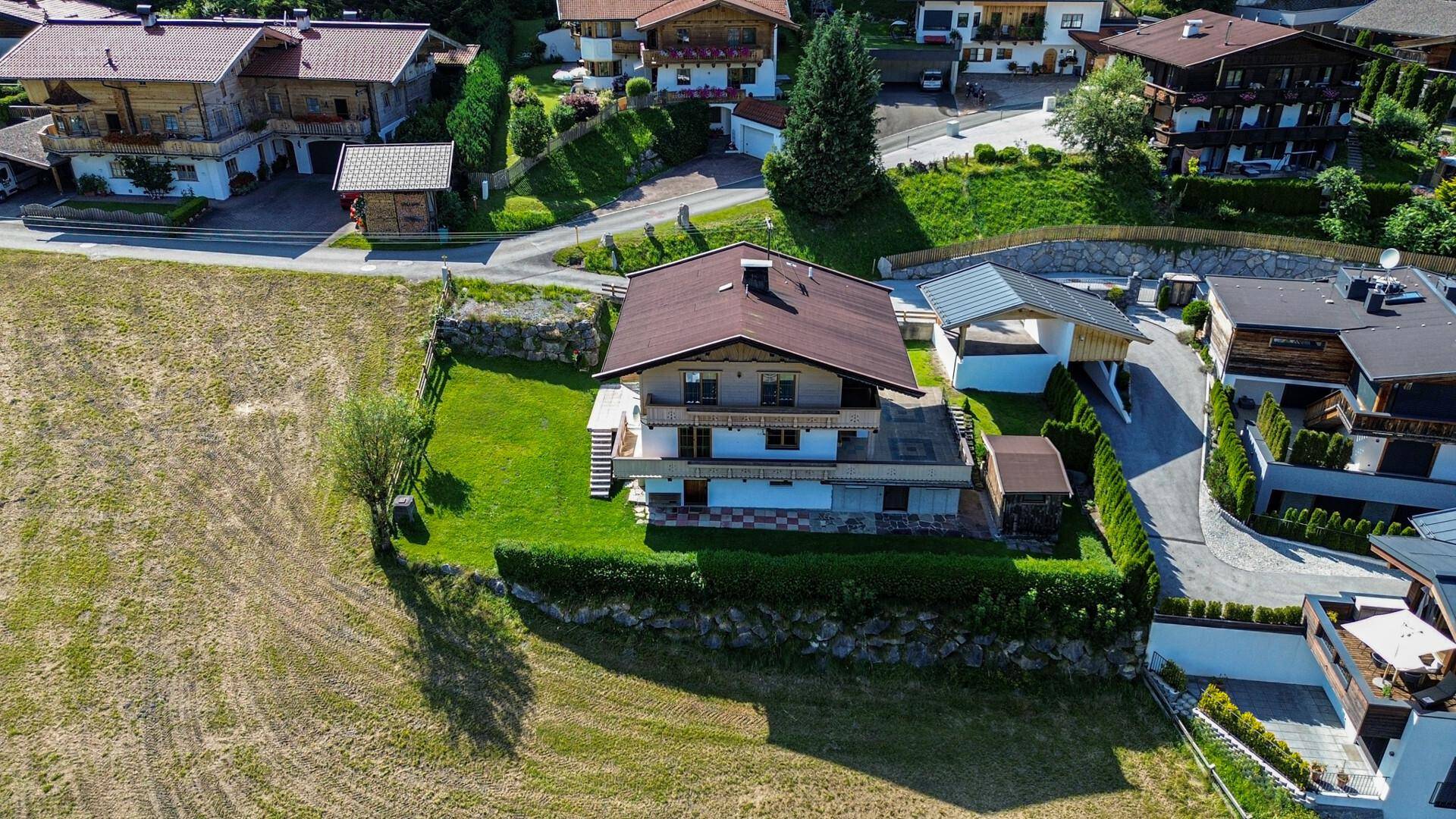 Luftaufnahme eines Einfamilienhauses mit Garten und umliegender Wohnbebauung in ländlicher Umgebung.