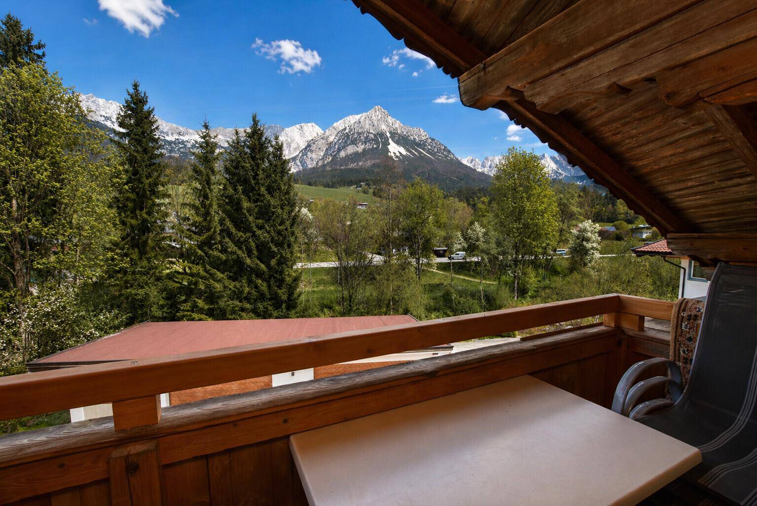 Gemütlicher Balkon mit Sitzgelegenheiten und atemberaubendem Blick auf die umliegende Bergwelt.