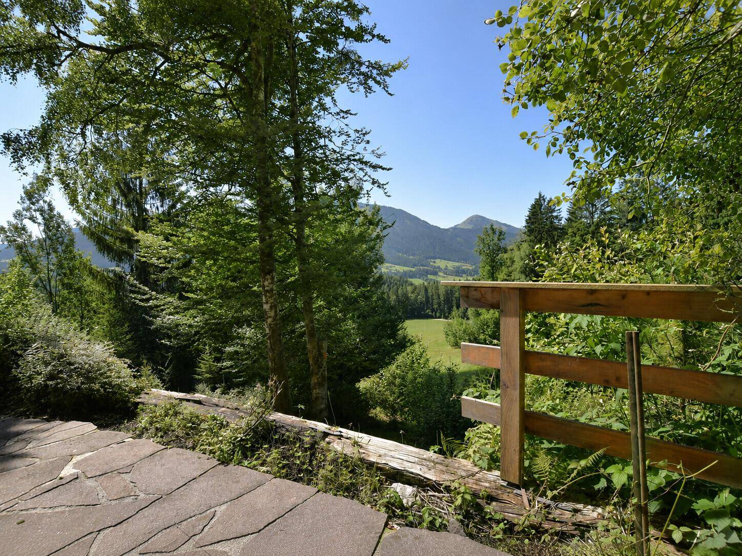 Naturbelassener Außenbereich mit Steinpfad und weitem Blick auf die umliegende Berglandschaft.
