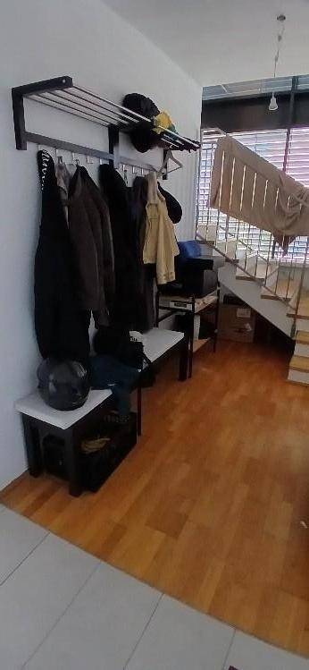 Eingangsbereich mit Garderobe, Holzboden und Treppe zum oberen Stockwerk.