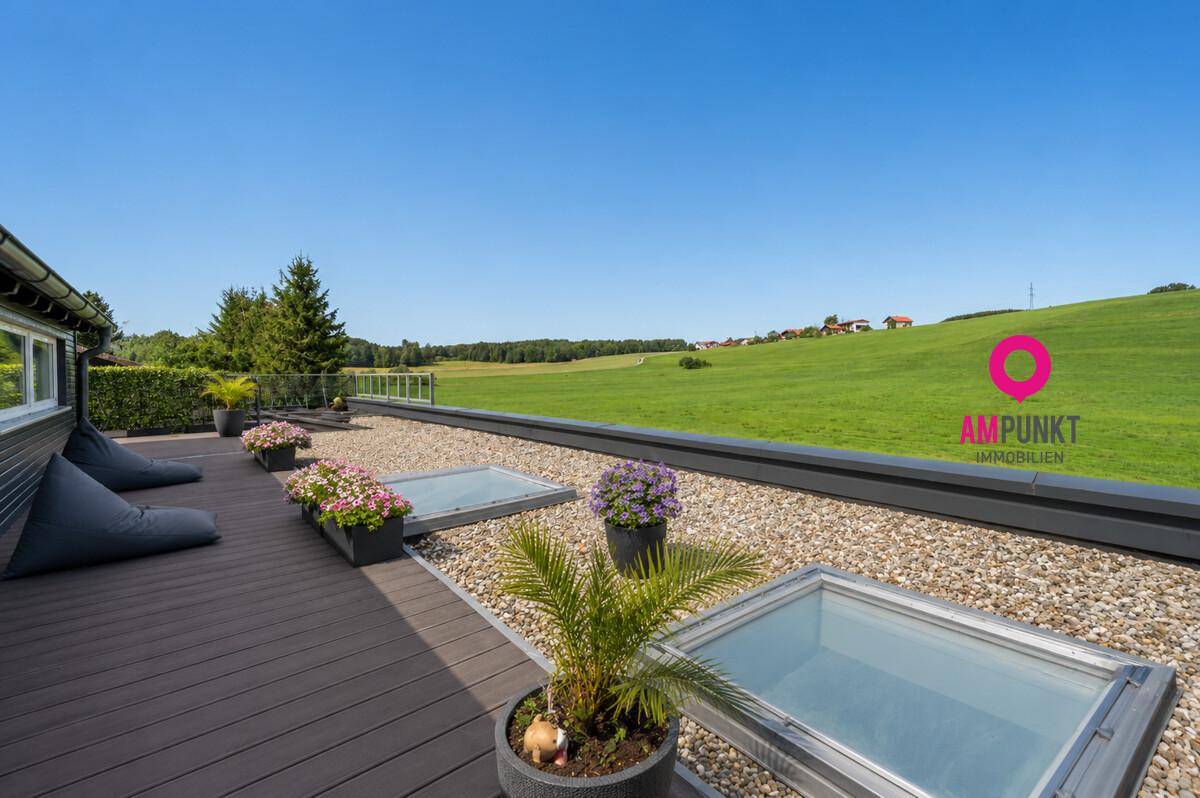 Große Dachterrasse mit weitem Blick über die grüne Landschaft und bequemen Sitzsäcken.