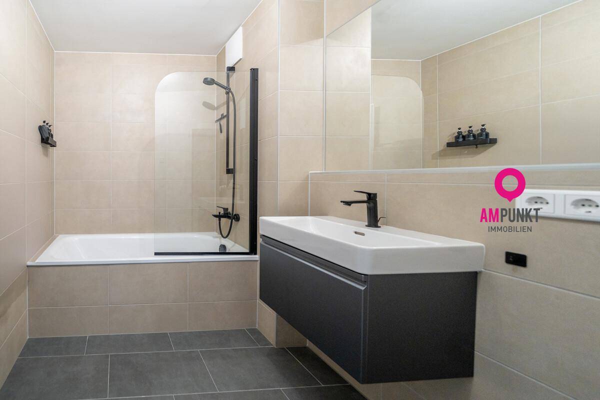 Modernes Badezimmer mit Badewanne, Duschbereich und schwebendem Waschtisch.