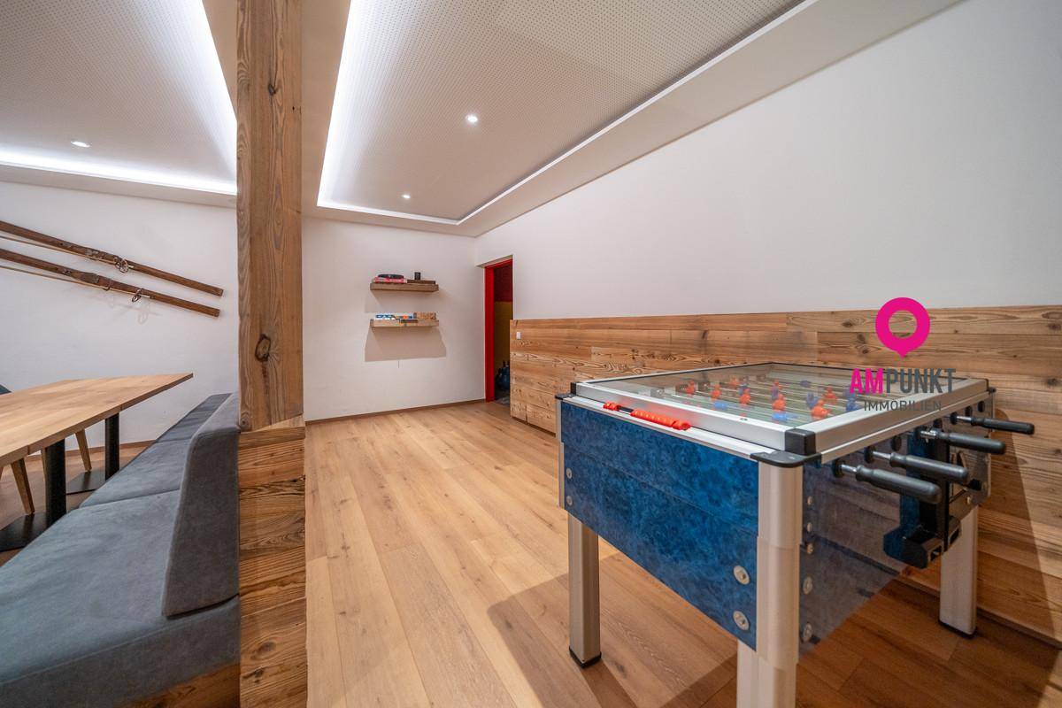 Spielzimmer mit Holzboden, Tischfußball und rustikaler Wanddekoration, ideal für Unterhaltung und Freizeit.