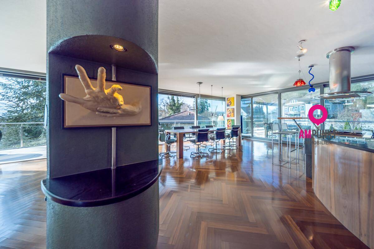 Geräumiger offener Wohnbereich mit Essbereich, Kücheninsel und Panoramablick ins Grüne.