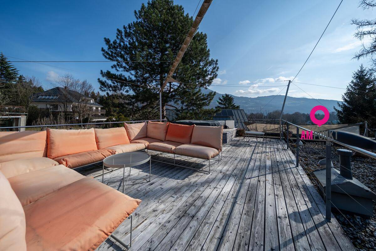 Geräumige Holzterrasse mit bequemen Lounge-Möbeln und weitem Blick in die Natur.
