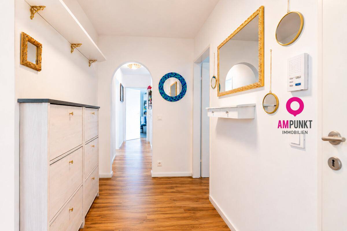 Heller Eingangsbereich mit Laminatboden, Schuhschrank und dekorativen Spiegeln.