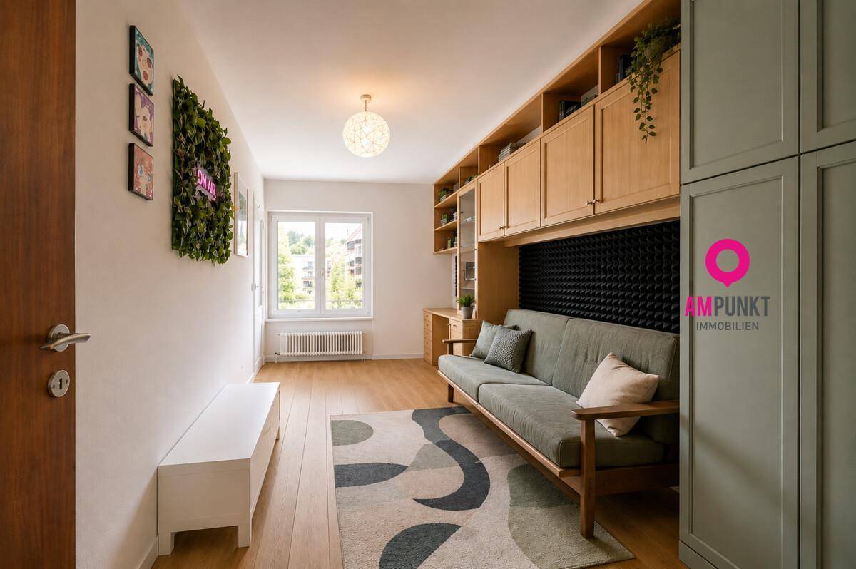 Renoviertes Arbeitszimmer mit modernem Sofa, Holzboden und integrierten Schränken.