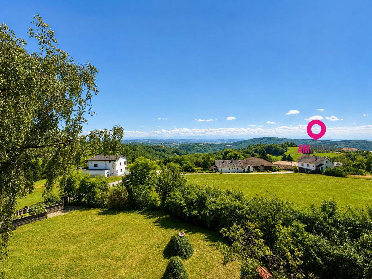 Weitläufiger Gartenbereich mit gepflegtem Rasen und Panoramablick auf die umliegende Landschaft.