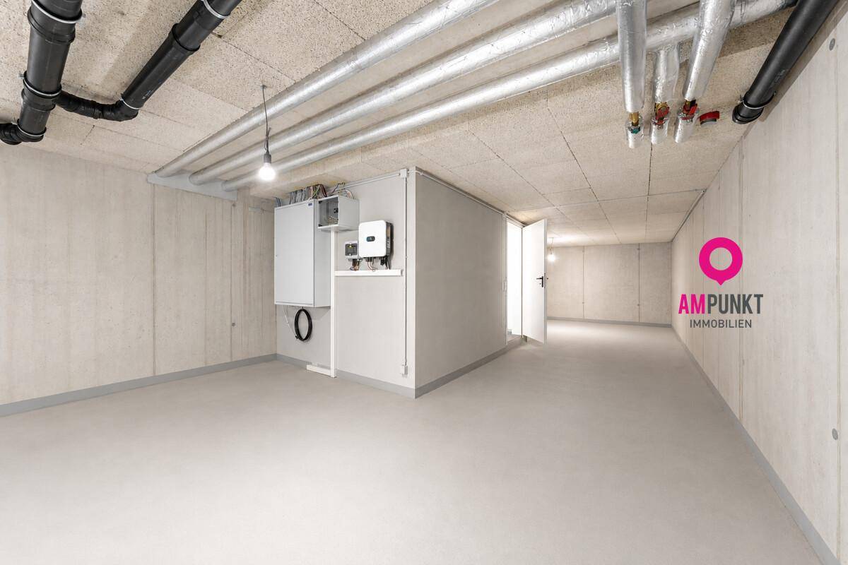 Geräumiger Kellerraum mit Betonboden, sichtbaren Leitungen und Technikinstallationen.
