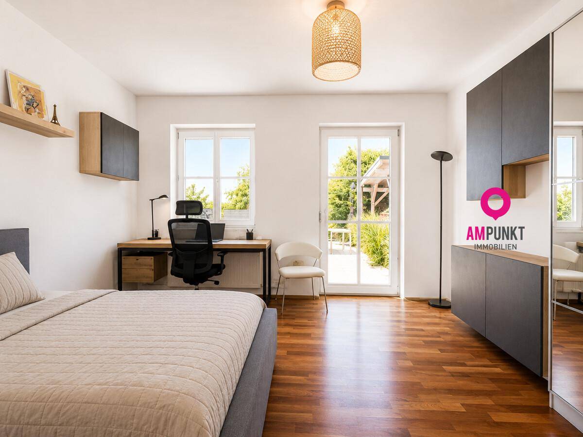 Schlafzimmer mit Holzboden, Schreibtisch und Zugang zu einem Außenbereich.