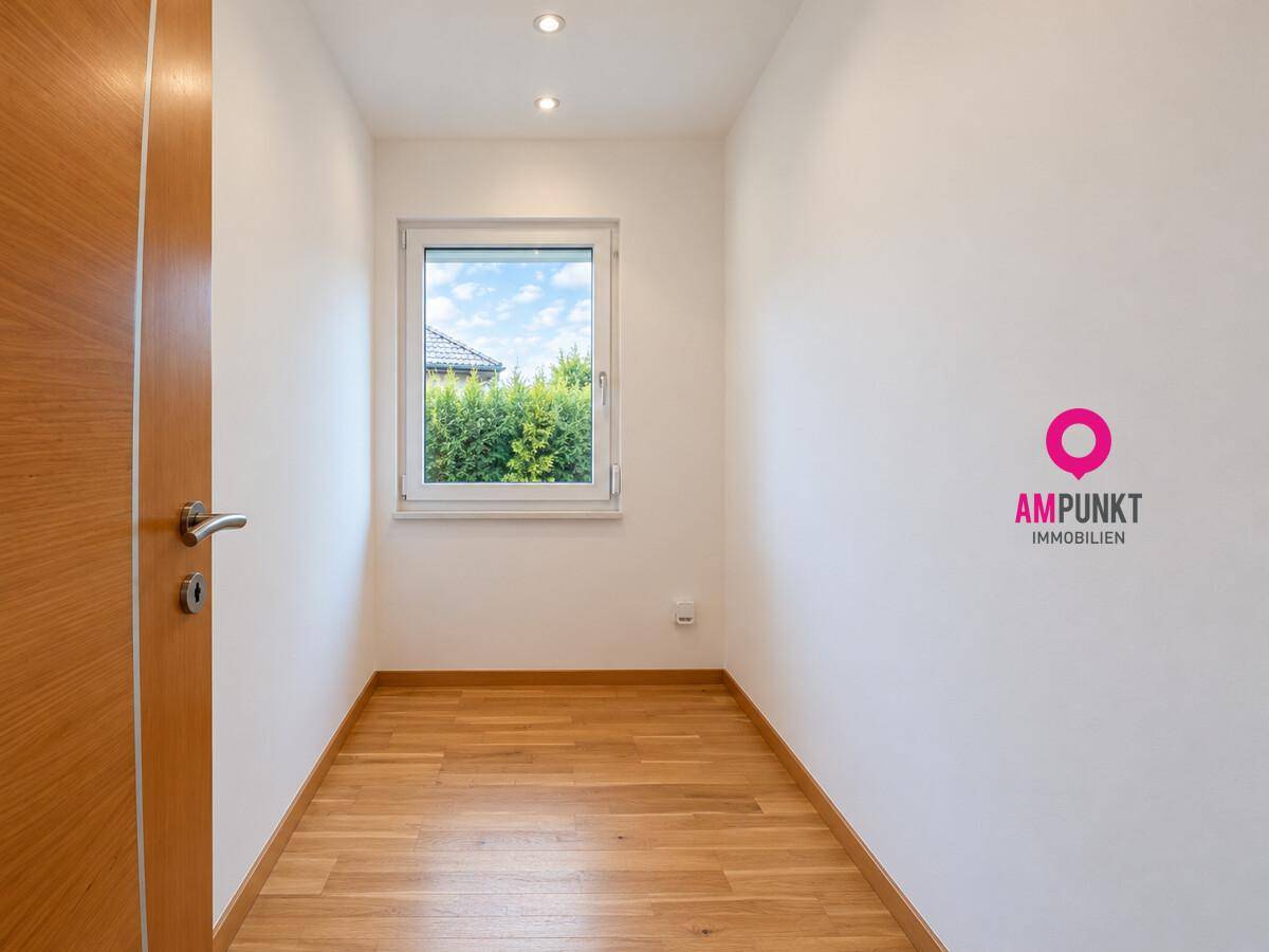 Kleines, helles Zimmer mit Holzboden und Fenster, ideal als Büro oder Abstellraum.