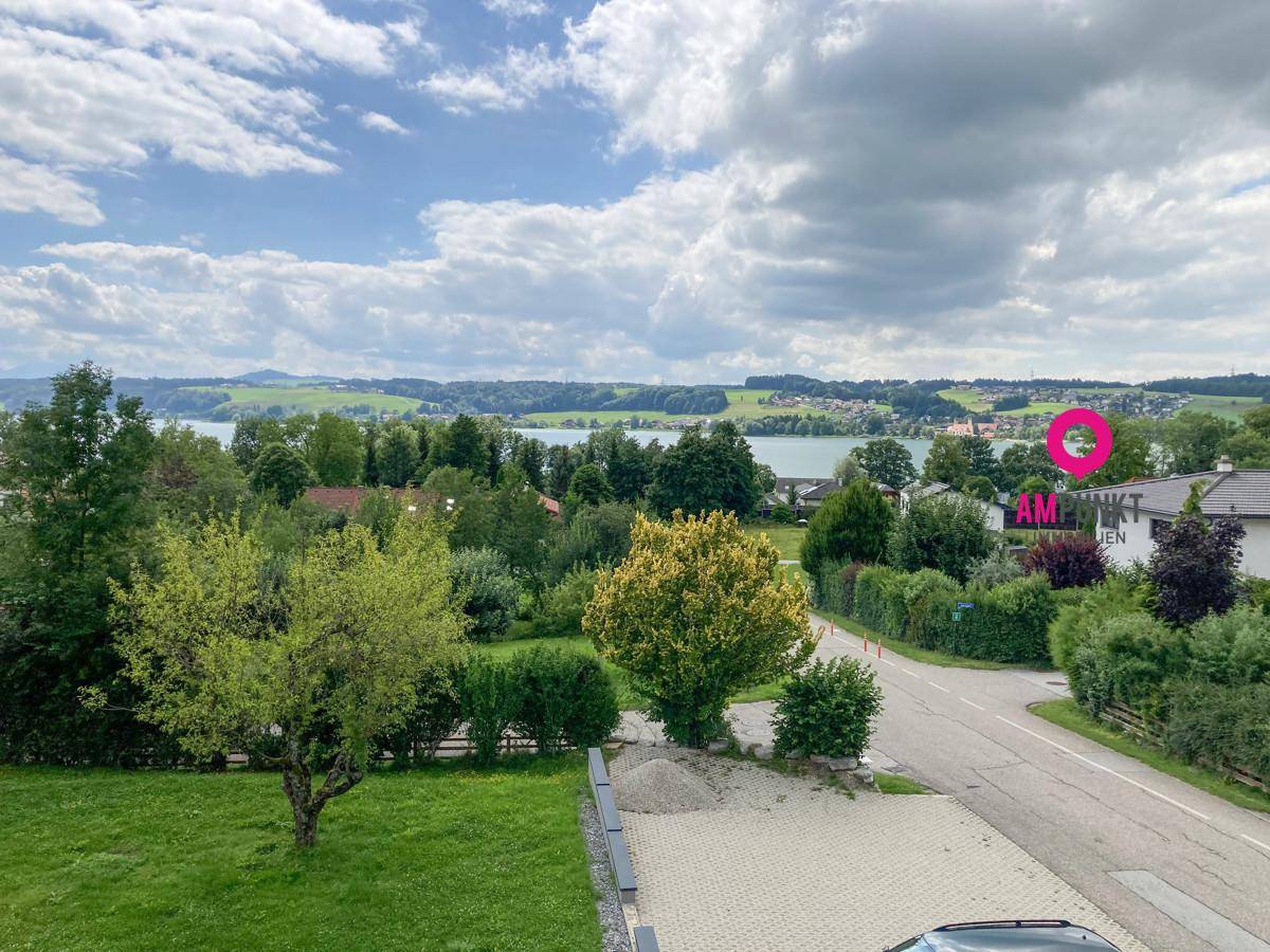 Weitläufiger Ausblick über die Wohngegend mit See und grüner Hügellandschaft.