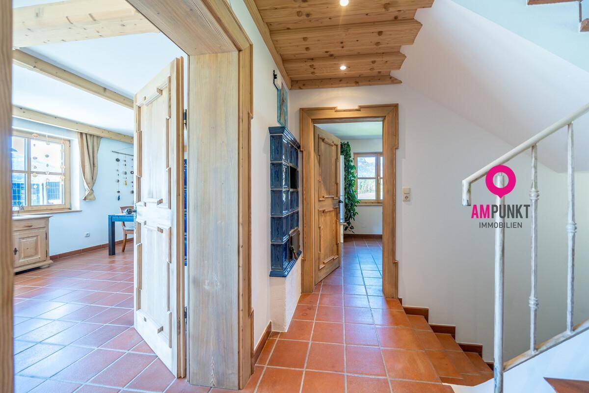 Heller Flur mit Terrakottafliesen, Holzdecken und Zugang zu verschiedenen Räumen.