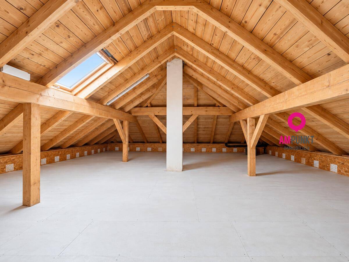 Geräumiger Dachboden mit sichtbaren Holzbalken, Dachfenster und viel Ausbaupotenzial.