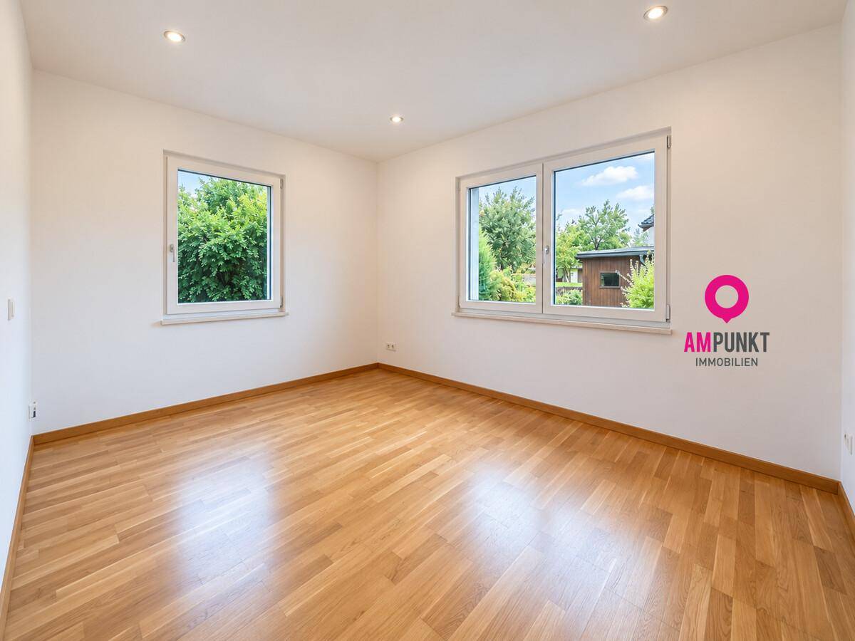 Helles Zimmer mit Holzboden und Blick ins Grüne, ideal als Schlaf- oder Arbeitszimmer.
