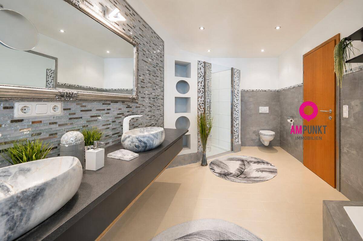 Großes Badezimmer mit Doppelwaschbecken, begehbarer Dusche und modernen Fliesen.