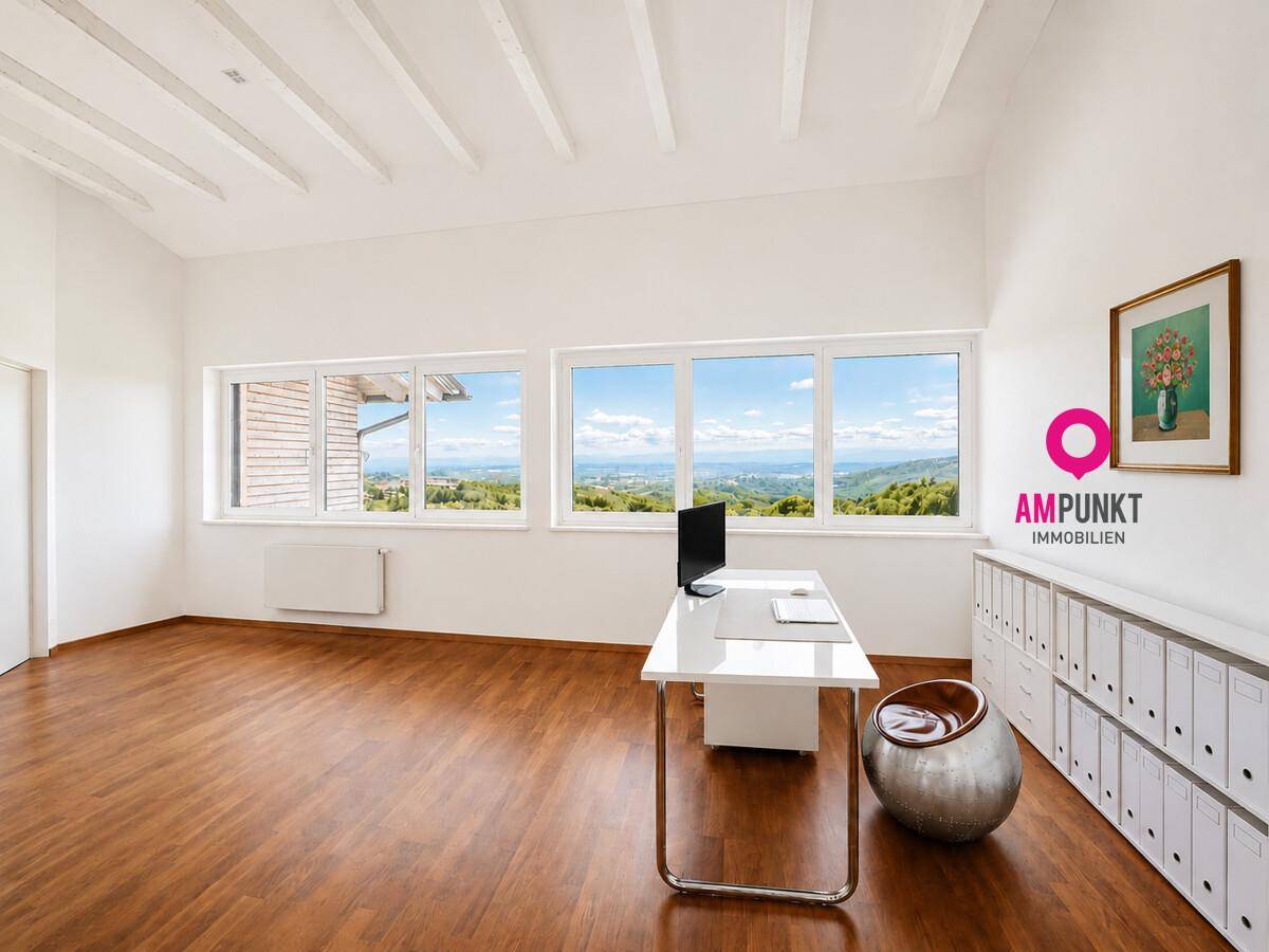 Helles Büro mit Holzboden, großen Fenstern und Panoramablick auf die Landschaft.