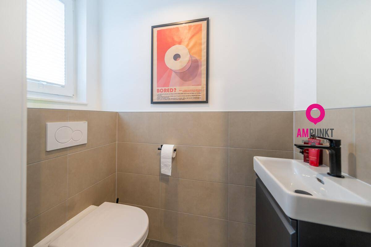 Modernes Gäste-WC mit Wand-WC, kleinem Waschbecken und Fenster.